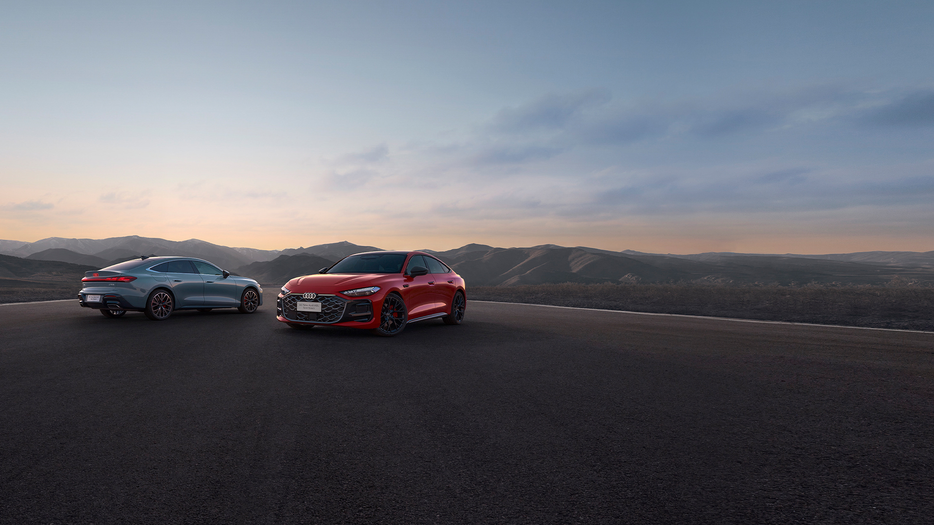 طراز Audi A5L Sportback لعام ٢٠٢٦ بلون أحمر، على خلفية منظر جبلي عند الغسق