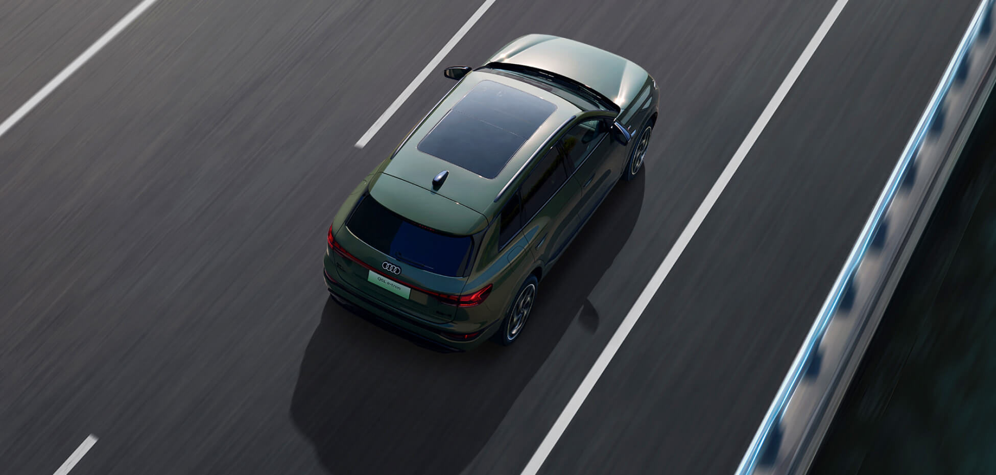 طراز Audi Q6 لعام ٢٠٢٦ بلون أخضر غامق، من زاوية علوية، أثناء القيادة في طريق حضري