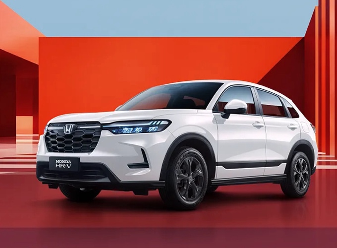 Модель 2026 года HONDA HR-V, белый кузов, фронтальный вид на фоне красно-оранжевого фона