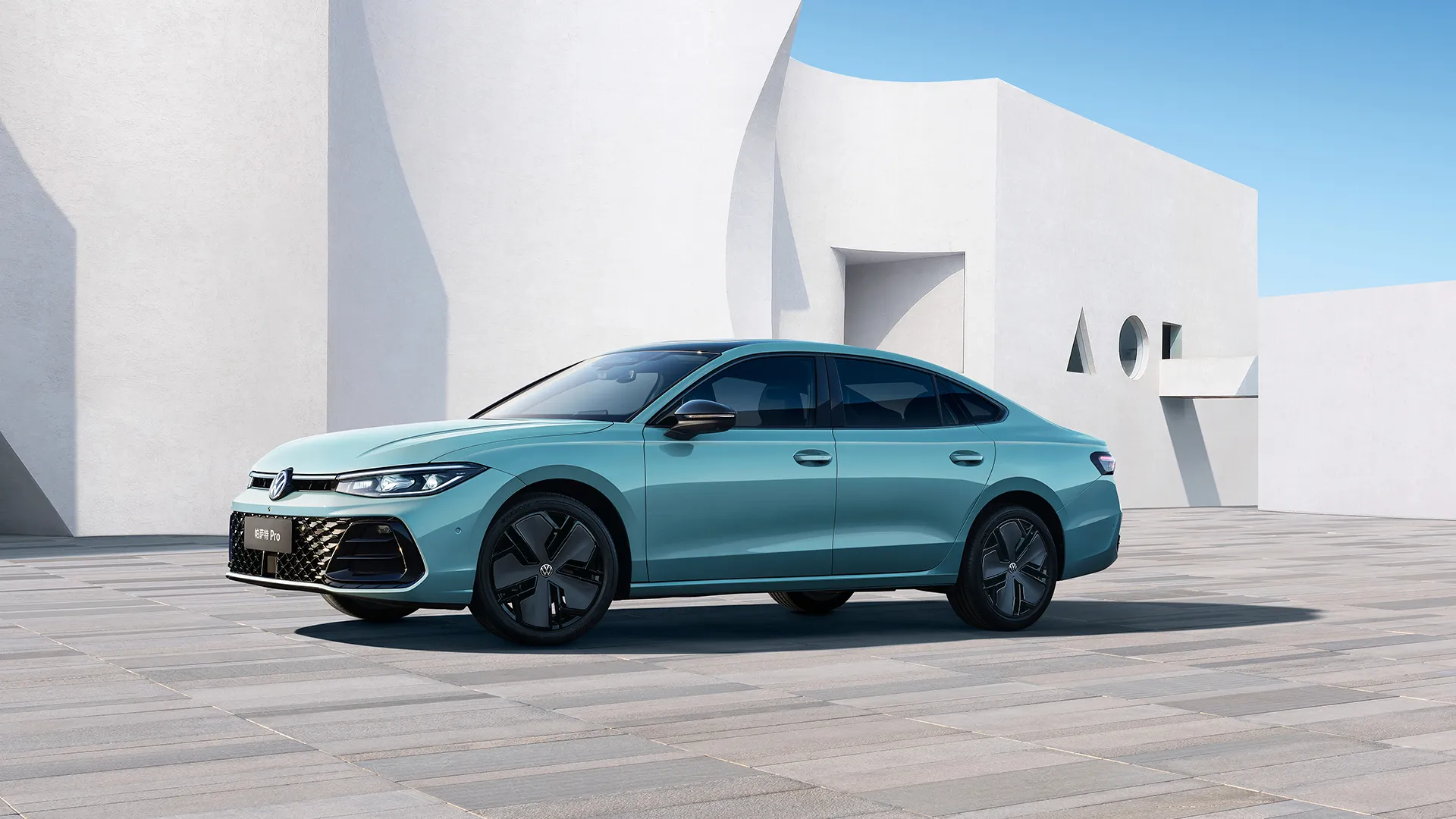 2026 Passat Pro front view in Lake Blue, with Hyundai architecture in background