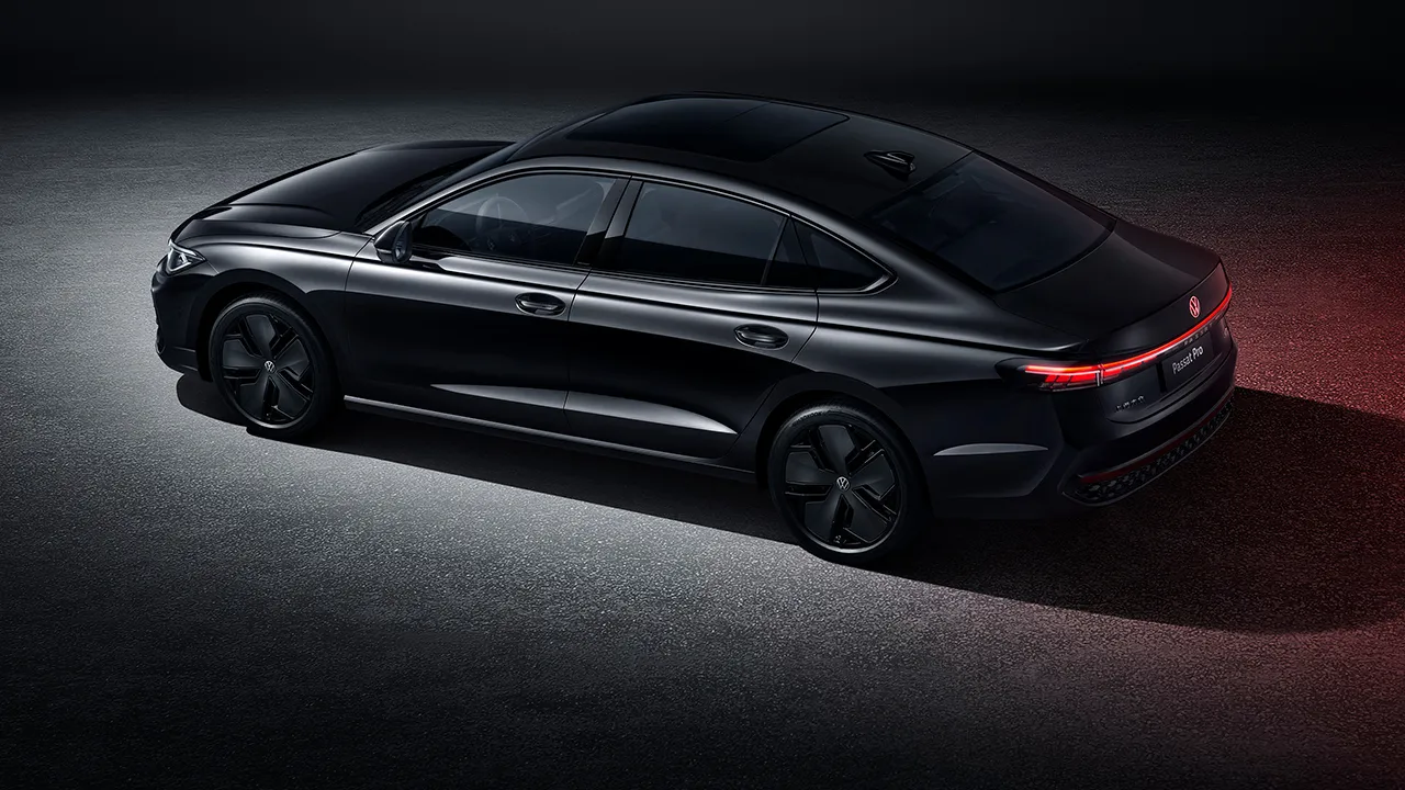 Full-body shot of the 2026 Passat Pro taken from the right side, in Obsidian Black, against a dark-toned studio background.