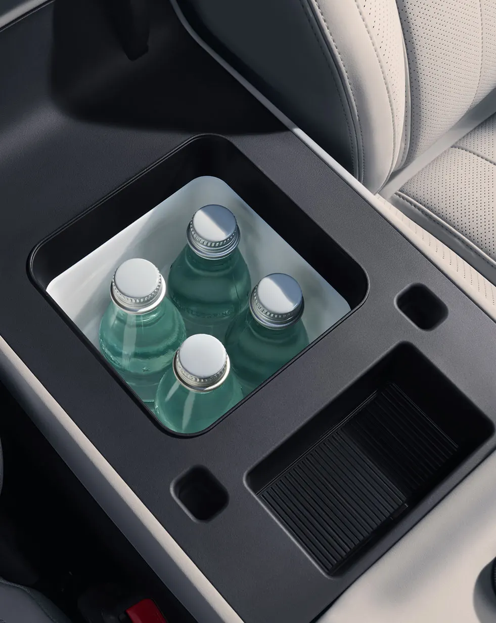Détail de l'intérieur de la Titanium 7 2026, montrant un compartiment de rangement contenant trois bouteilles d'eau.