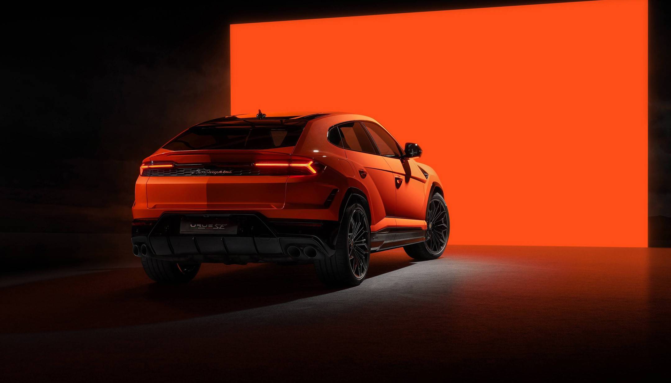 Vue arrière de la Lamborghini Urus SE 2025 sur fond rouge