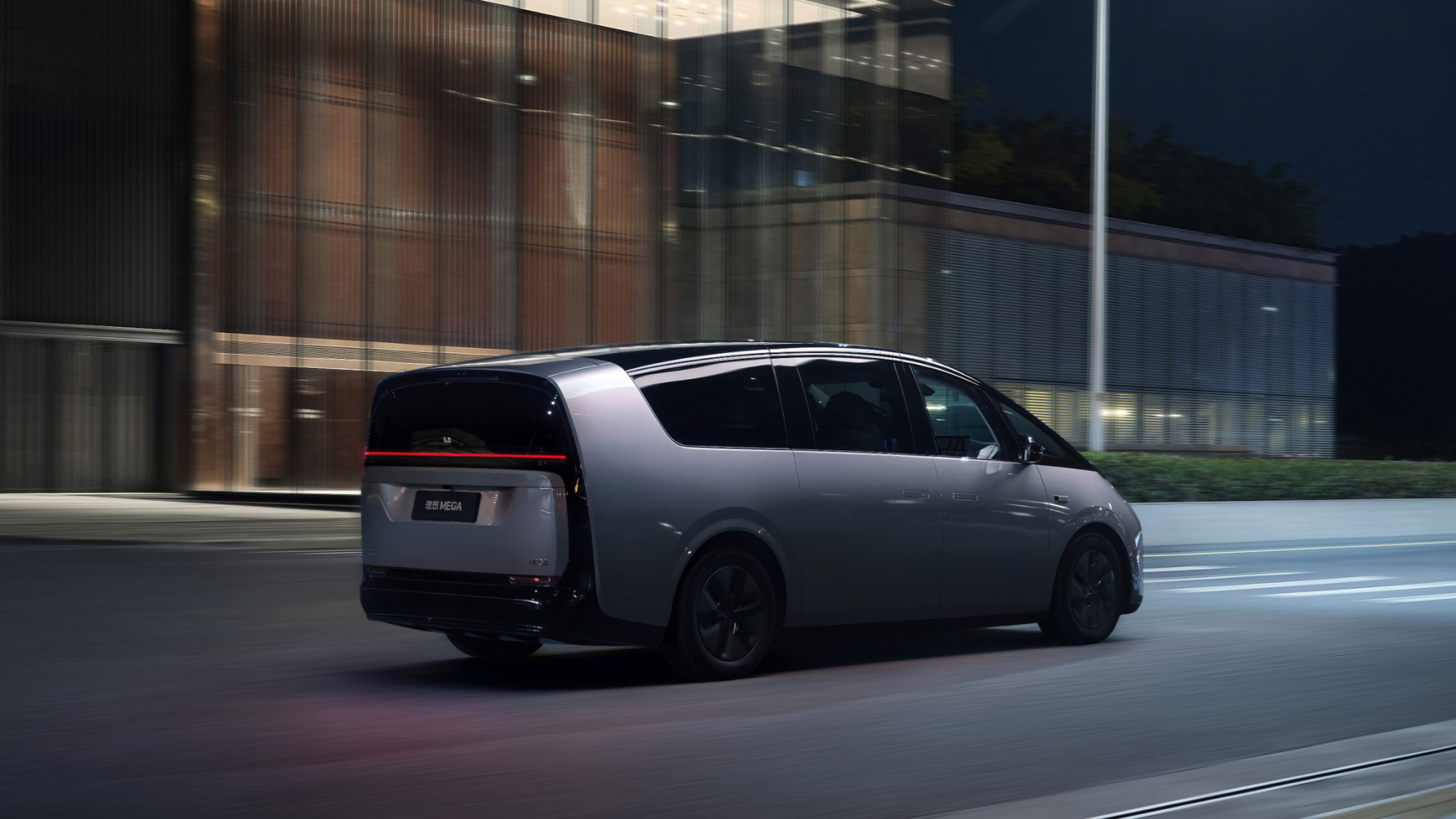 2026 Li MEGA in Galaxy Silver, driving through an urban night scene — three-quarter rear side view