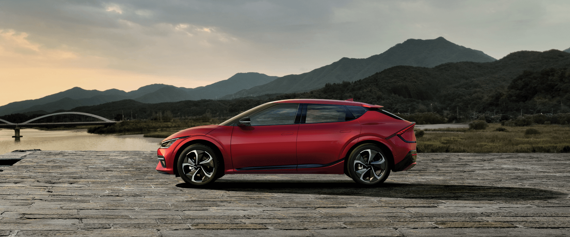 Side View of 2026 KIA EV6 in Red, Set Against Natural FENGON Background