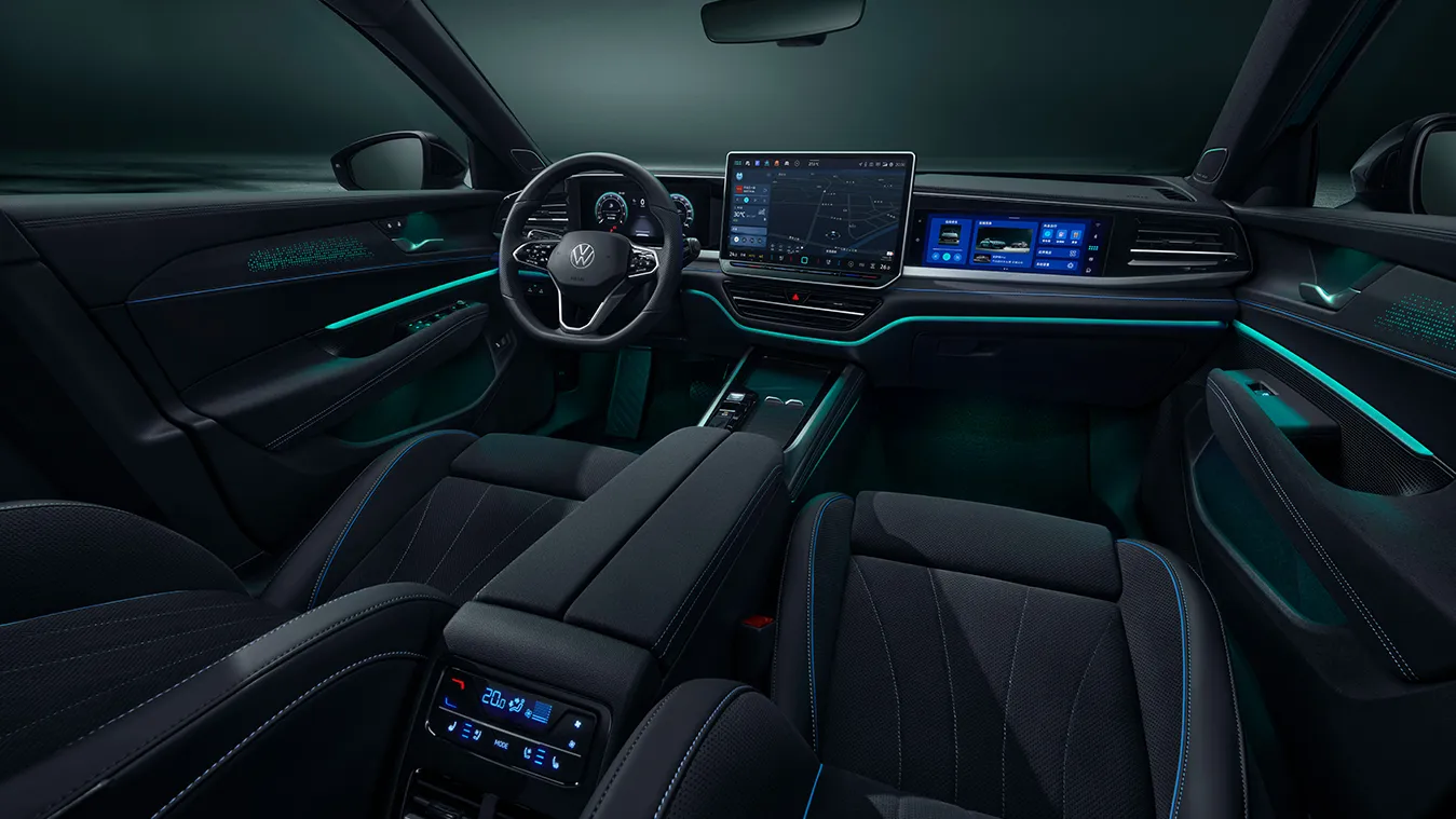 Intérieur panoramique de la Passat 2026 de SAIC Volkswagen, sièges noirs avec ambiance lumineuse bleue, écran central très technologique