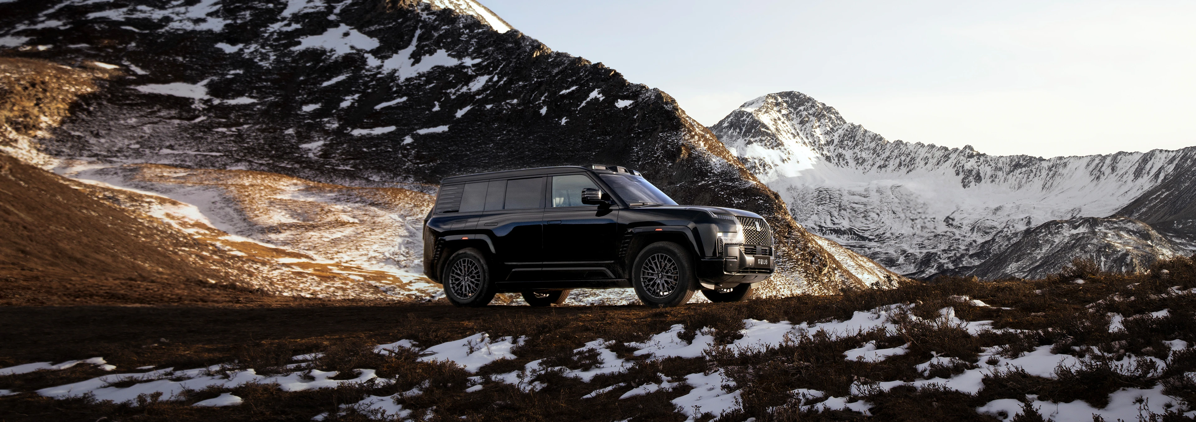 Front view of the 2026 Yangwang U8 in Obsidian Black, set against outdoor alpine meadow and snow-capped mountain scenery.