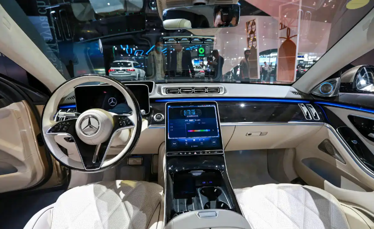 Official interior image of the Maybach S 580 e, showing First Class rear seats and the hyperscreen